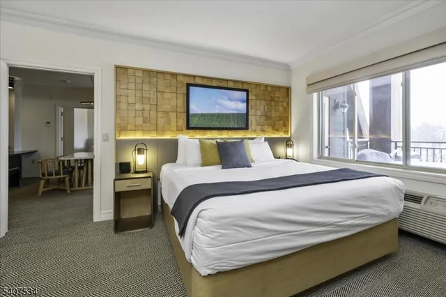 a bedroom with a bed and large windows