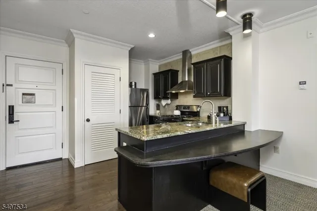 a dining hall with stainless steel appliances granite countertop a stove refrigerator and a microwave