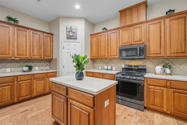 a kitchen with stainless steel appliances granite countertop white cabinets and a stove top oven