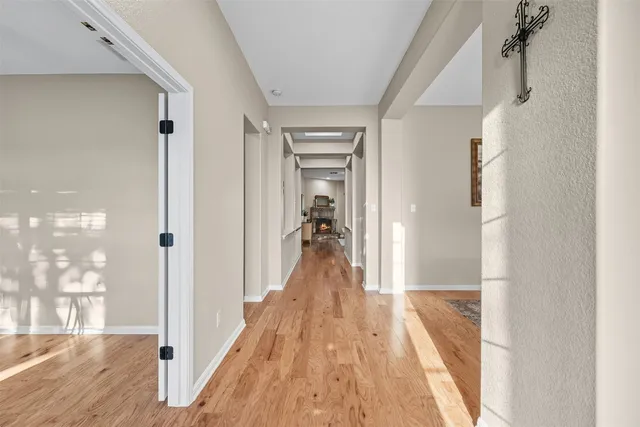 a view of a hallway with a livingroom and a hall with wooden floor