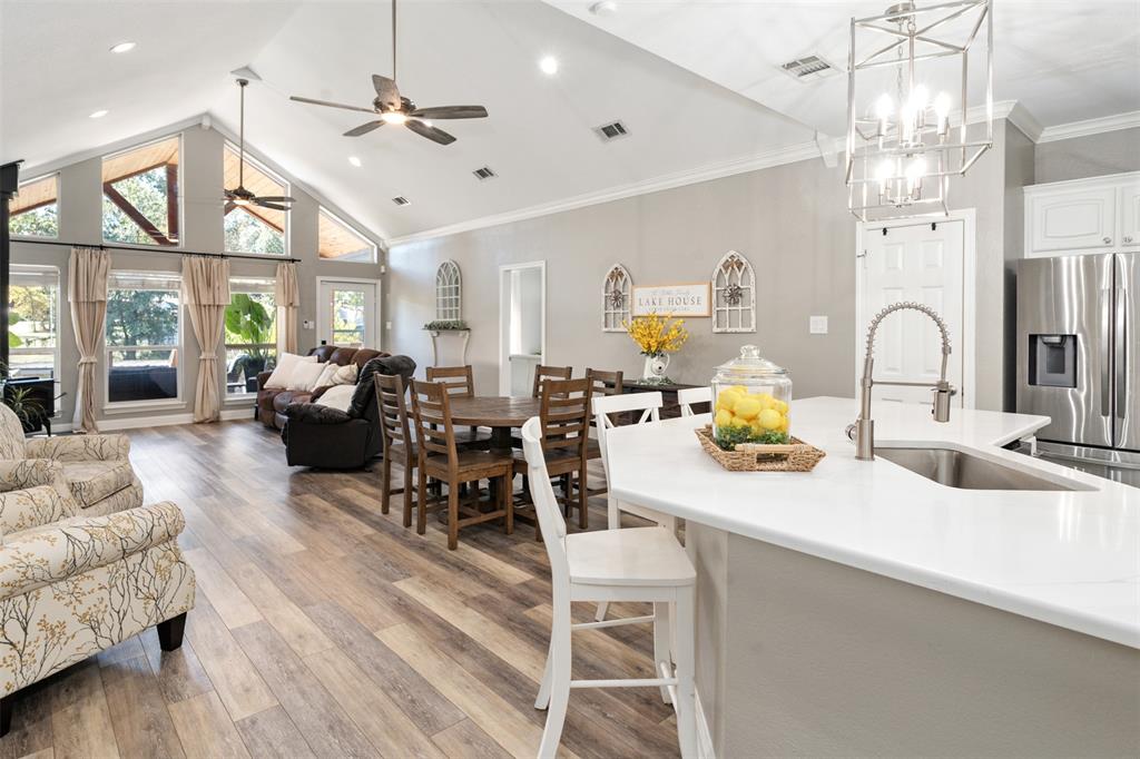 127 Rueda Encina Street Gun Barrel City, TX 75156 - Photo 13 of 39 a kitchen island with a dining table a sink stainless steel appliances and wooden floor