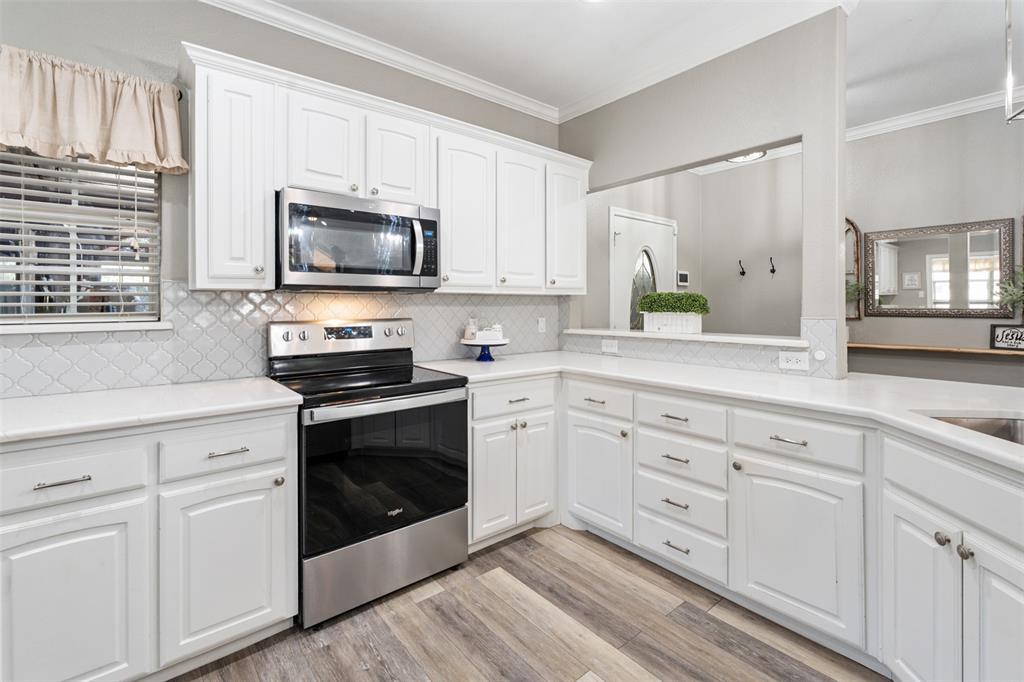 127 Rueda Encina Street Gun Barrel City, TX 75156 - Photo 9 of 39 a kitchen with white cabinets stainless steel appliances and sink