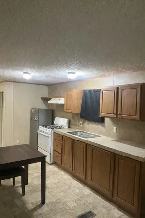 a kitchen with a sink cabinets and wooden floor