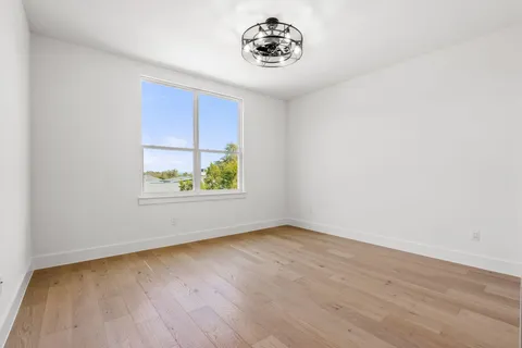 a view of a room with wooden floor and chandelier fan