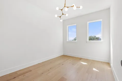 an empty room with a ceiling fan and window