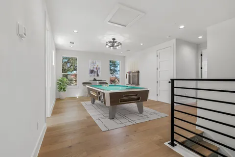a living room with furniture a wooden floor and a potted plant