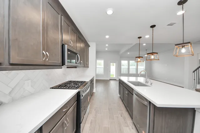 a kitchen with a sink stove and cabinets