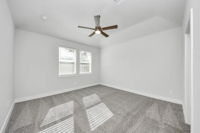 an empty room with windows and fan