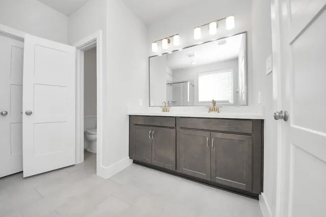 a bathroom with a double vanity sink and mirror