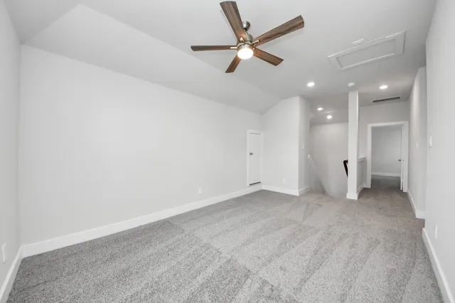 an empty room with a ceiling fan and window