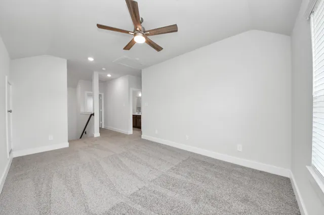 an empty room with a ceiling fan and a window