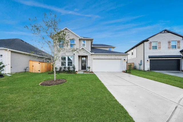 a front view of a house with a garden and yard