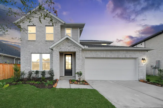 a front view of a house with a yard and garage