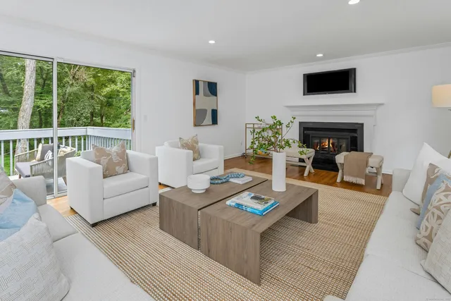 a living room with furniture a fireplace and a flat screen tv