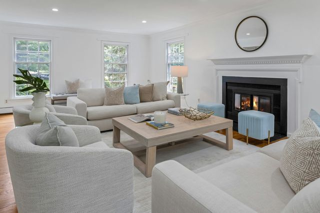 a living room with furniture a fireplace and window