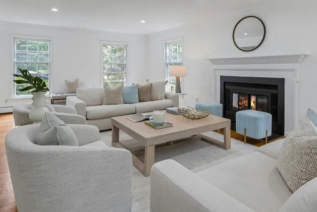 a living room with furniture a fireplace and window