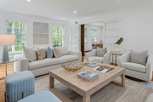 a living room with furniture a pot on table and a lamp