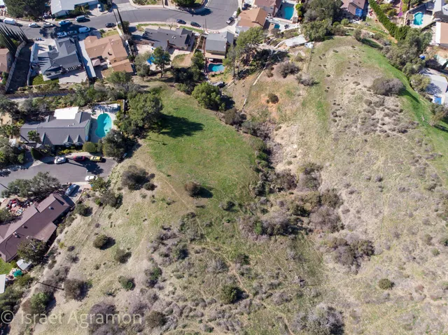 a view of a dry yard with lots of bushes