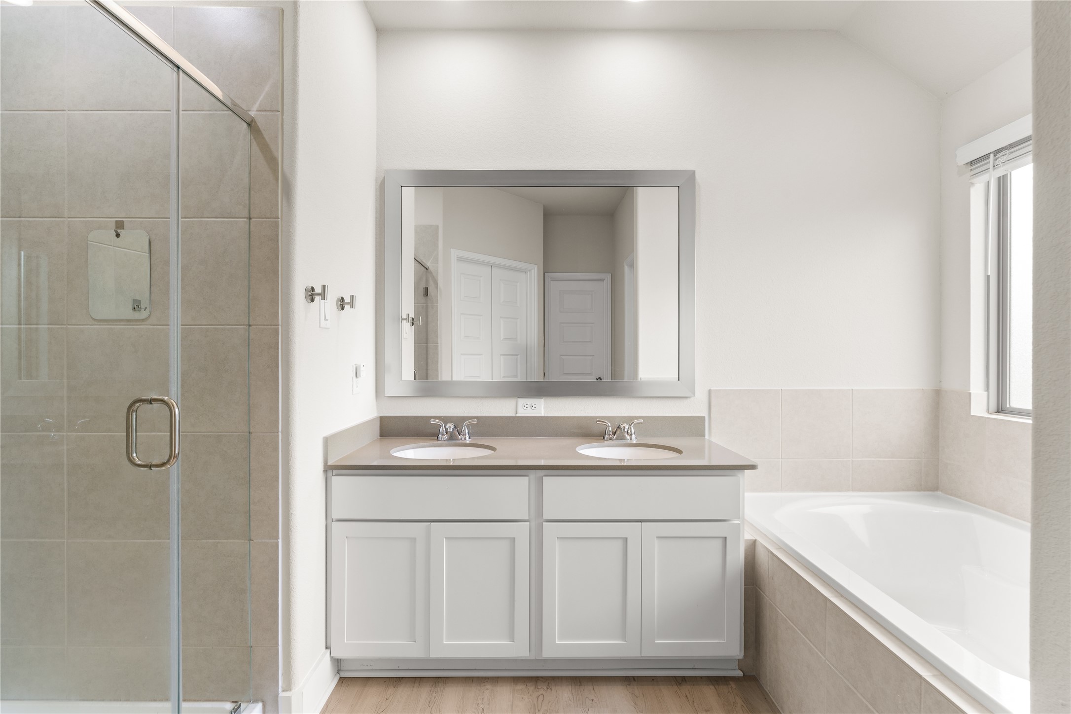 4001 Baja Lane Houston, TX 77045 - Photo 16 of 27 Designed to support the morning routine with ease, the primary ensuite features dual vanities, a dedicated glass-enclosed shower, and a soaking tub, allowing multiple functions to happen comfortably at once.