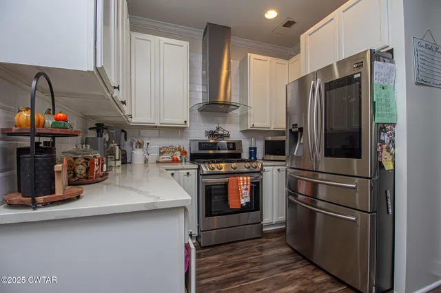 a kitchen with stainless steel appliances granite countertop a refrigerator and a stove