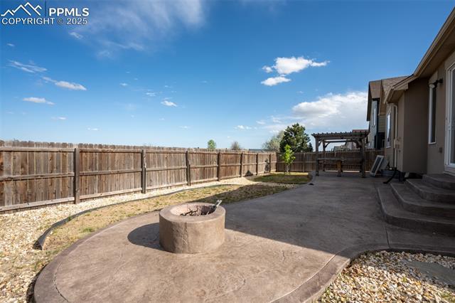 1985 Reed Grass Way Colorado Springs, CO 80915 - Photo 33 of 36 Backyard with stamped concrete, pergola, and fire pit