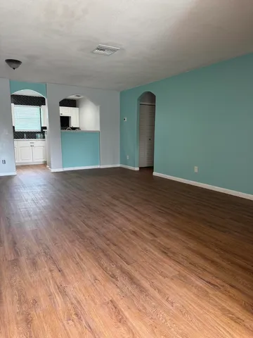 a view of empty room with wooden floor