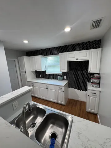 a kitchen that has a sink and a stove in it