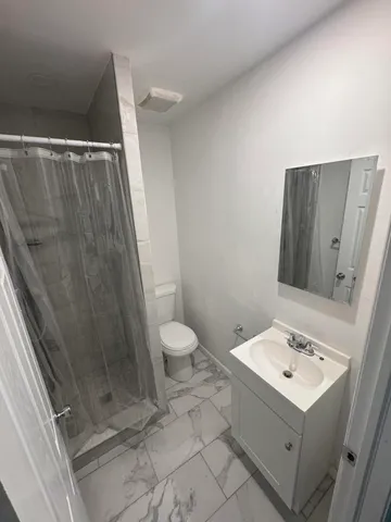 a bathroom with a sink toilet and shower