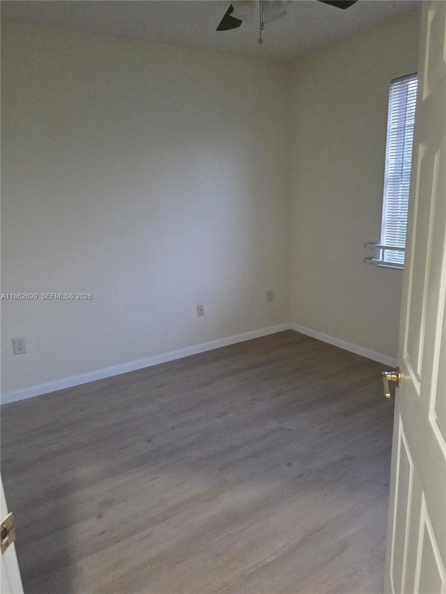 2584 Southwest 84th Terrace, Unit 101 Miramar, FL 33025 - Photo 13 of 19 an empty room with wooden floor and windows
