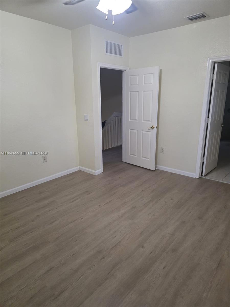 2584 Southwest 84th Terrace, Unit 101 Miramar, FL 33025 - Photo 16 of 19 an empty room with wooden floor and windows