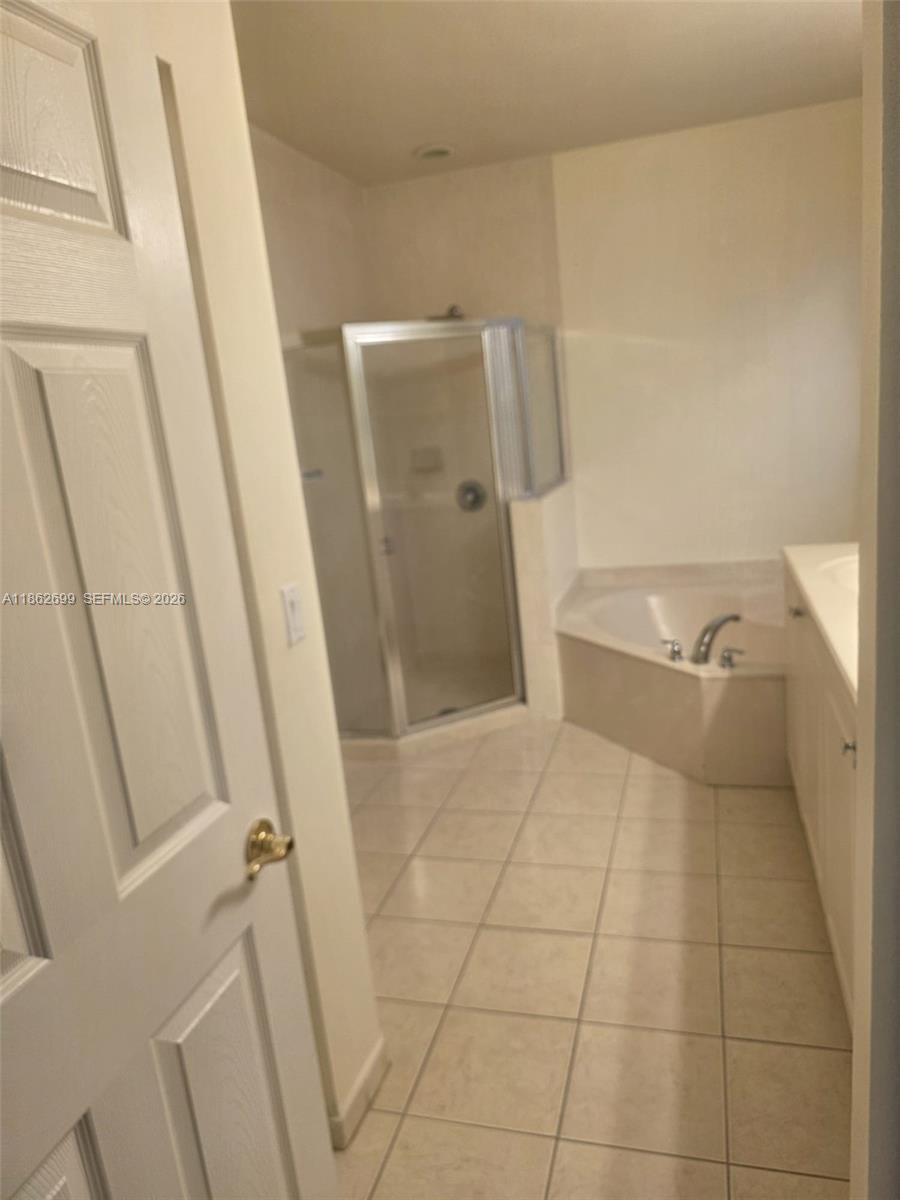 2584 Southwest 84th Terrace, Unit 101 Miramar, FL 33025 - Photo 18 of 19 a bathroom with a tub and a shower