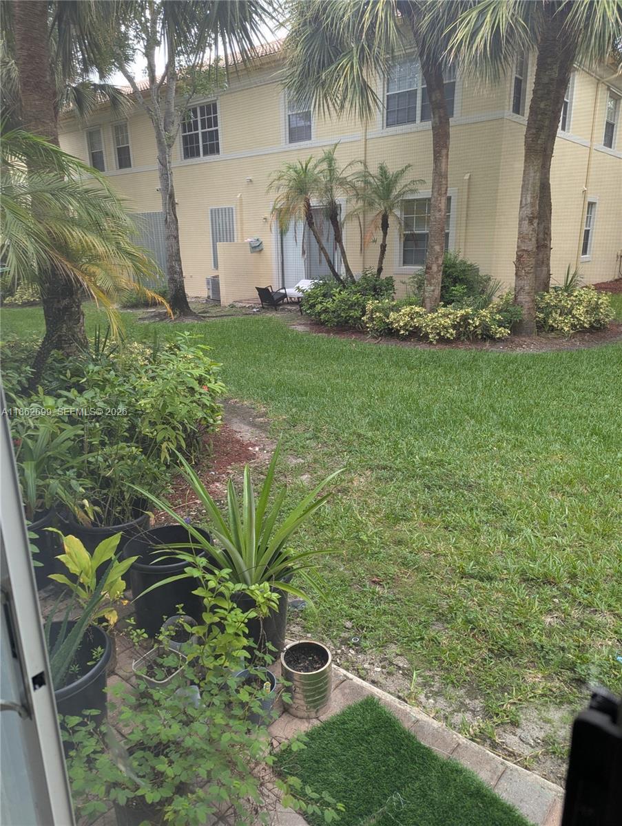 2584 Southwest 84th Terrace, Unit 101 Miramar, FL 33025 - Photo 19 of 19 a white house with a yard and plants