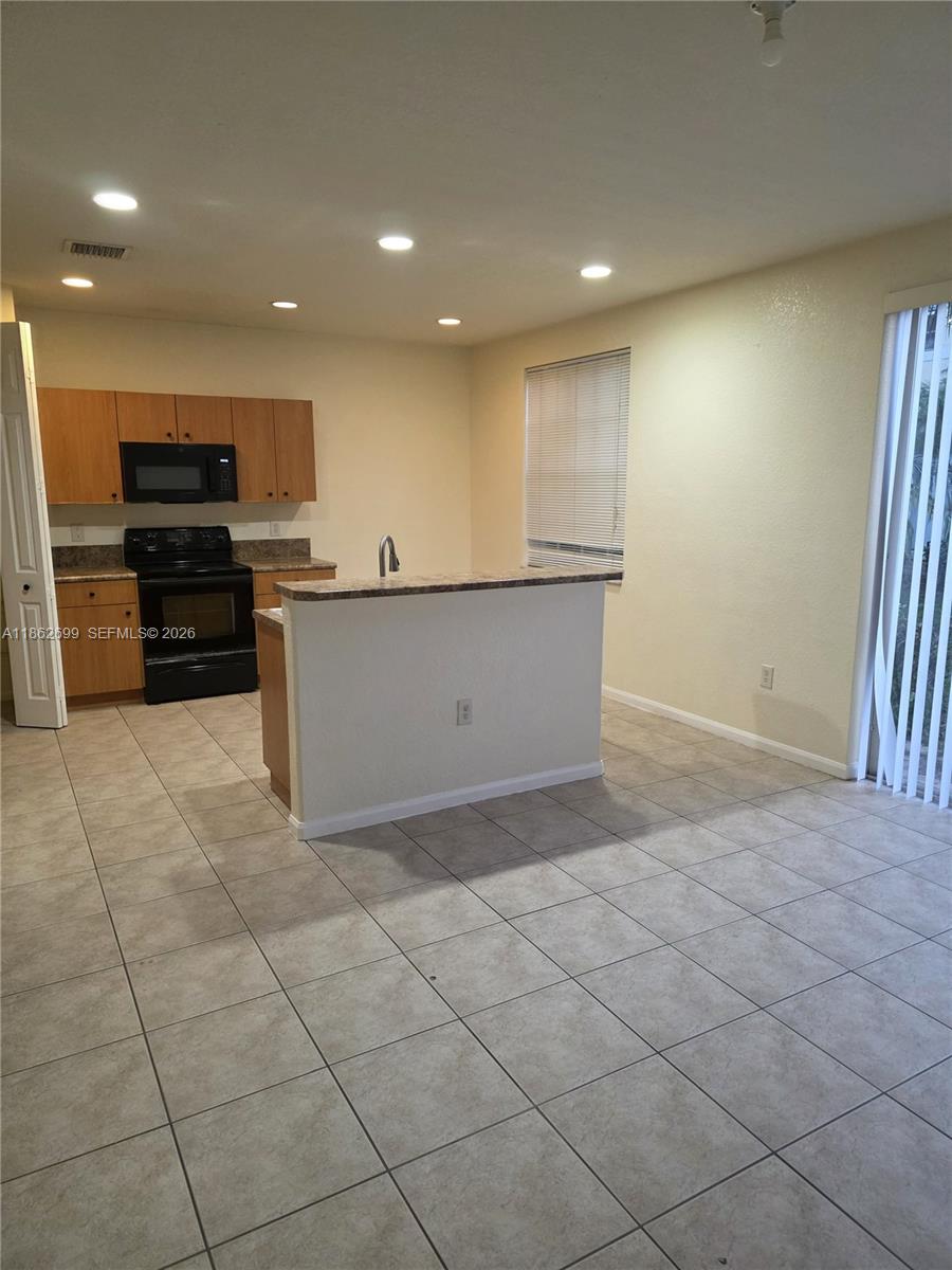 2584 Southwest 84th Terrace, Unit 101 Miramar, FL 33025 - Photo 2 of 19 a kitchen with stainless steel appliances a refrigerator and a stove top oven