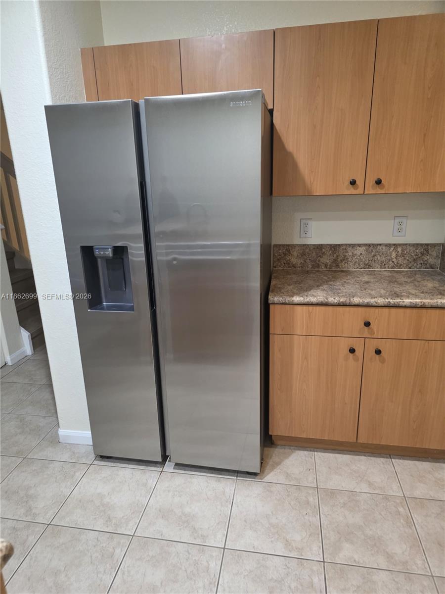 2584 Southwest 84th Terrace, Unit 101 Miramar, FL 33025 - Photo 5 of 19 a kitchen with a refrigerator and cabinets