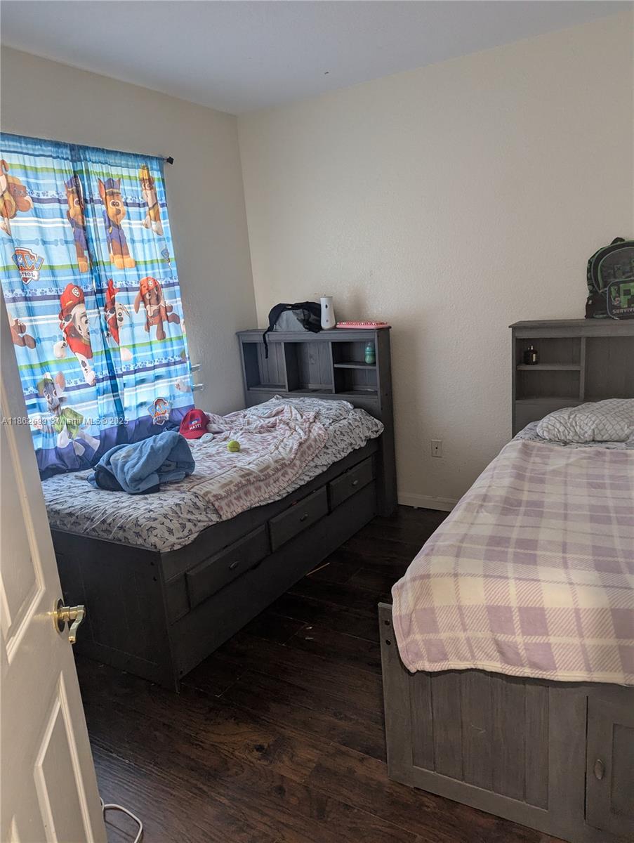 2584 Southwest 84th Terrace, Unit 101 Miramar, FL 33025 - Photo 9 of 11 a bedroom with bed and wooden floor