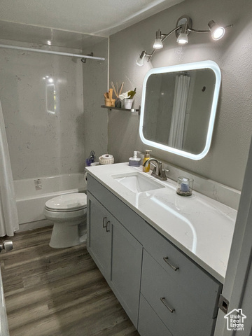 1874 South Main Street Orem, UT 84058 - Photo 11 of 15 Bathroom featuring vanity, shower / bathtub combination with curtain, and dark wood-style flooring