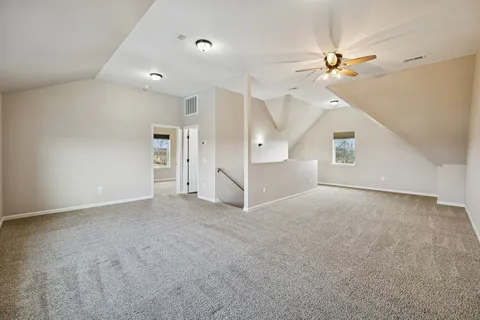 an empty room with windows and fan