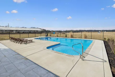 a front view of a house with a garden and trees
