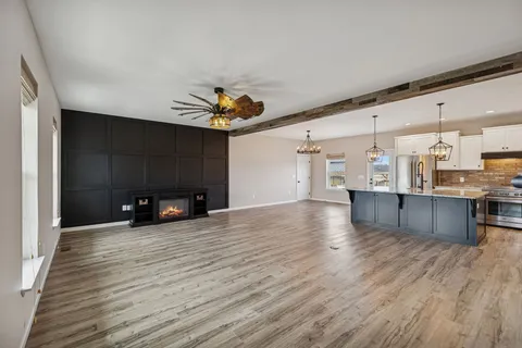 a view of a livingroom with wooden floor and stairs