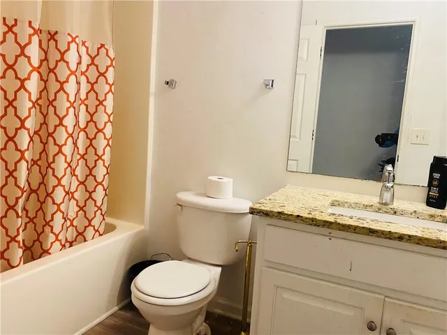 a bathroom with a granite countertop toilet sink and a mirror