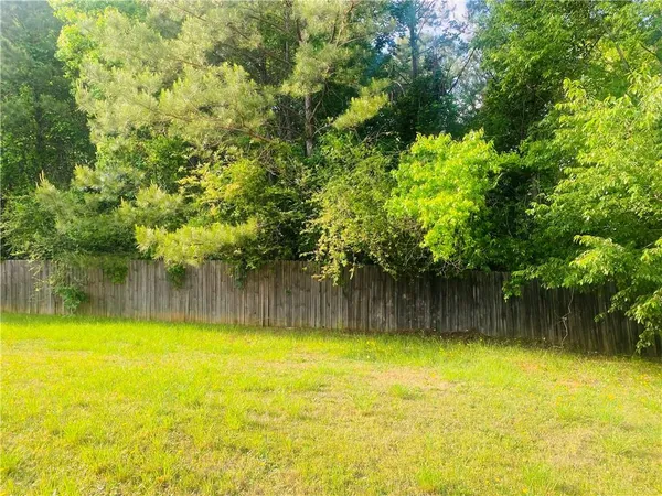 a view of a swimming pool with a patio and a yard