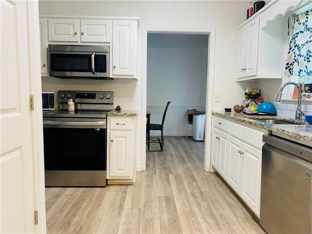 a kitchen with stainless steel appliances a stove a sink and a microwave