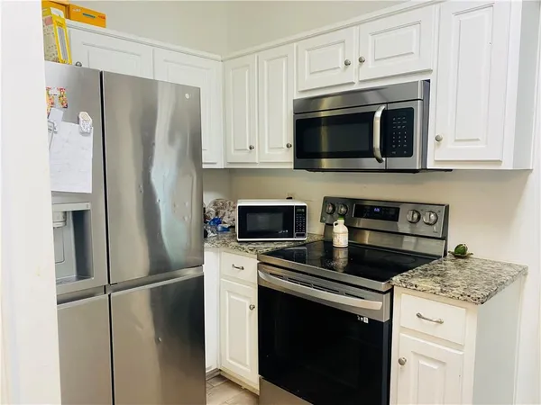 a kitchen with stainless steel appliances a stove microwave and refrigerator
