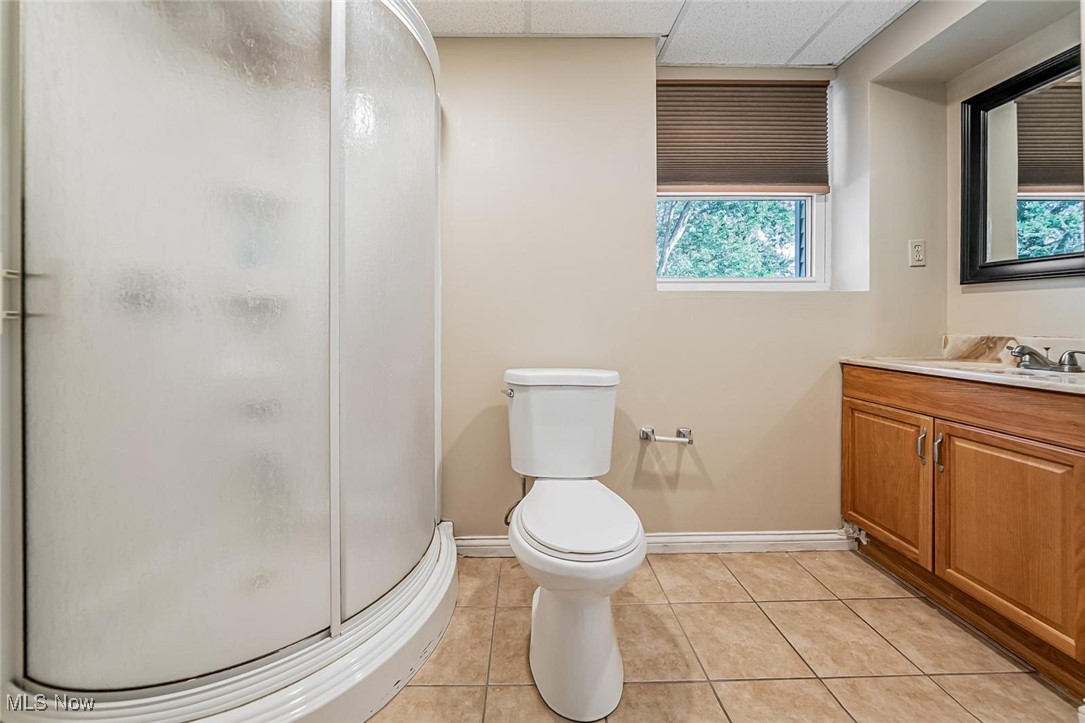 1489 Sunnyacres Road Akron, OH 44321 - Photo 22 of 33 Full bathroom with light tile patterned floors, vanity, a stall shower, and a paneled ceiling