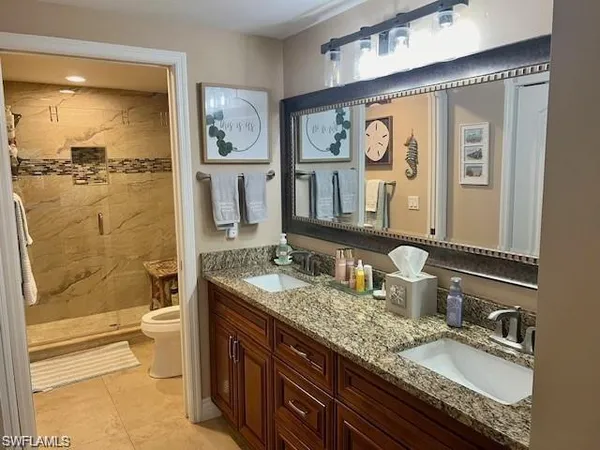 a bathroom with a granite countertop sink mirror toilet and bathtub