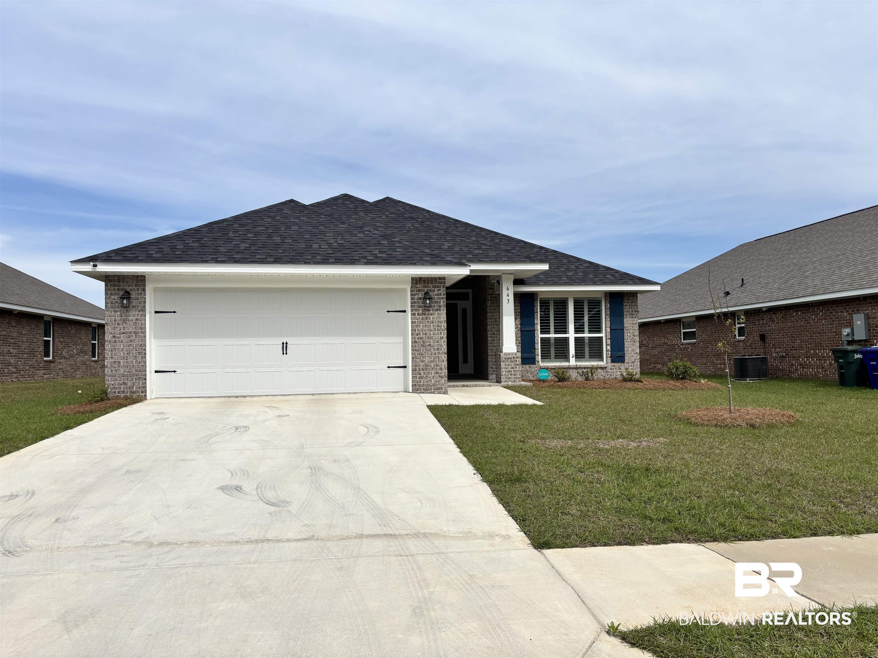643 Mayflower Drive Foley, AL 36535 - Photo 1 of 34 Ranch-style house featuring a front lawn, an attached garage, driveway, brick siding, and roof with shingles