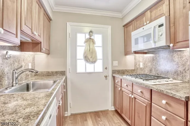 a kitchen with granite countertop a sink stove and cabinets