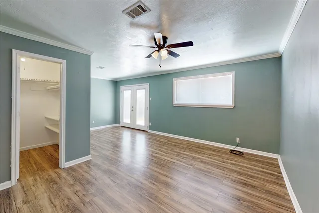 a view of a livingroom with wooden floor and a ceiling fan