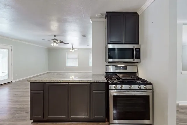 a kitchen with granite countertop a stove and a microwave