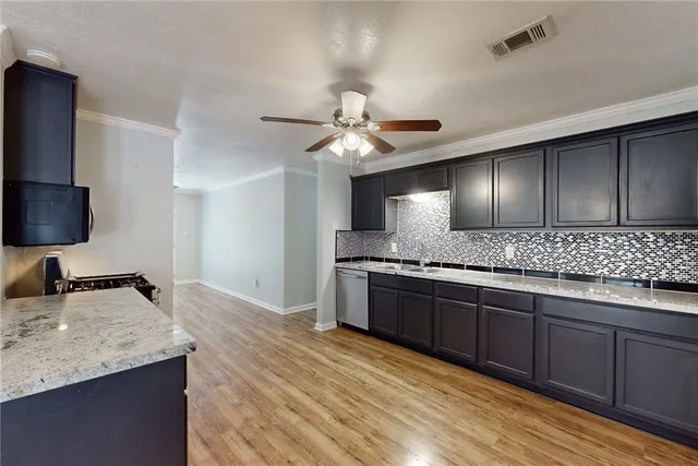 a large kitchen with granite countertop a sink and a stove